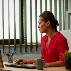 A woman sitting at her desk using a laptop.