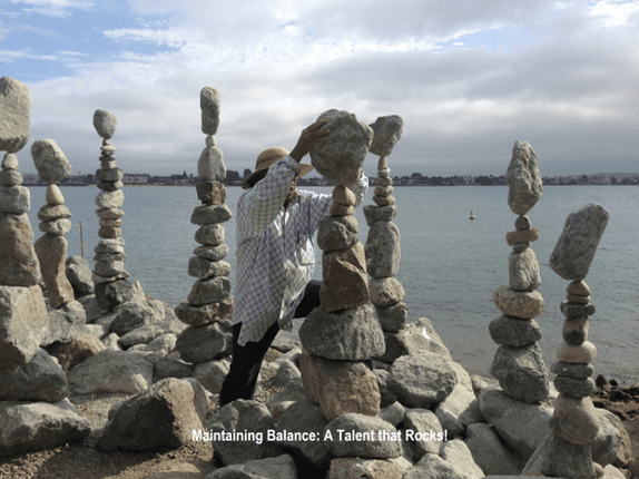 A person standing on rocks near the water.